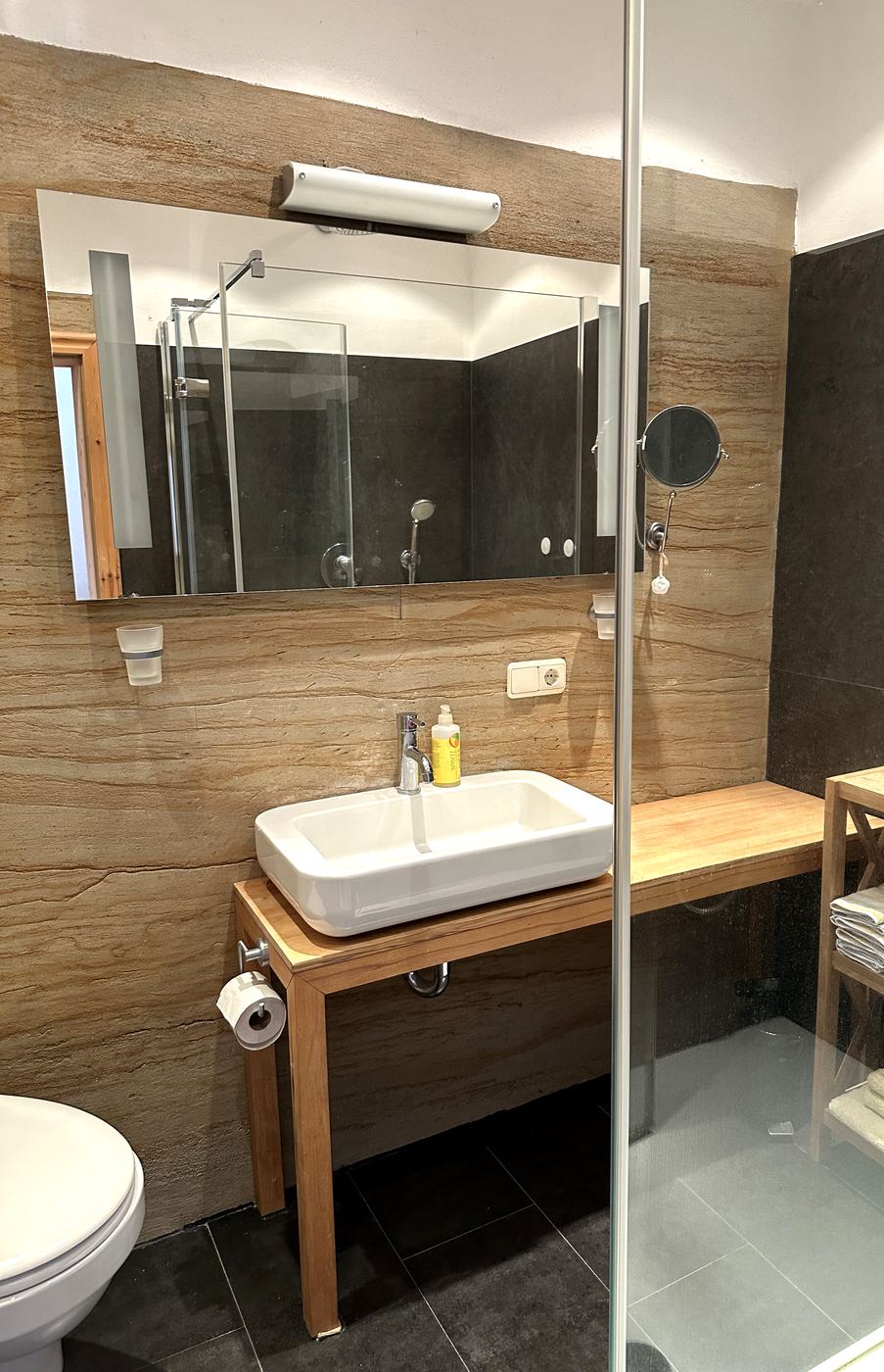 Bad mit Aufsatzwaschbecken auf Holztisch und Regendusche