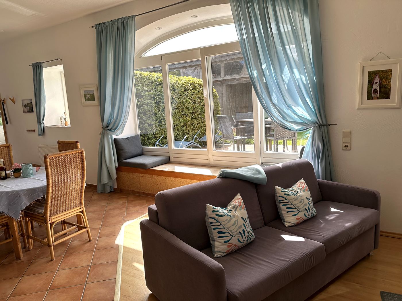 Wohnraum mit Bogenfenster, Sofa und Fensterbank